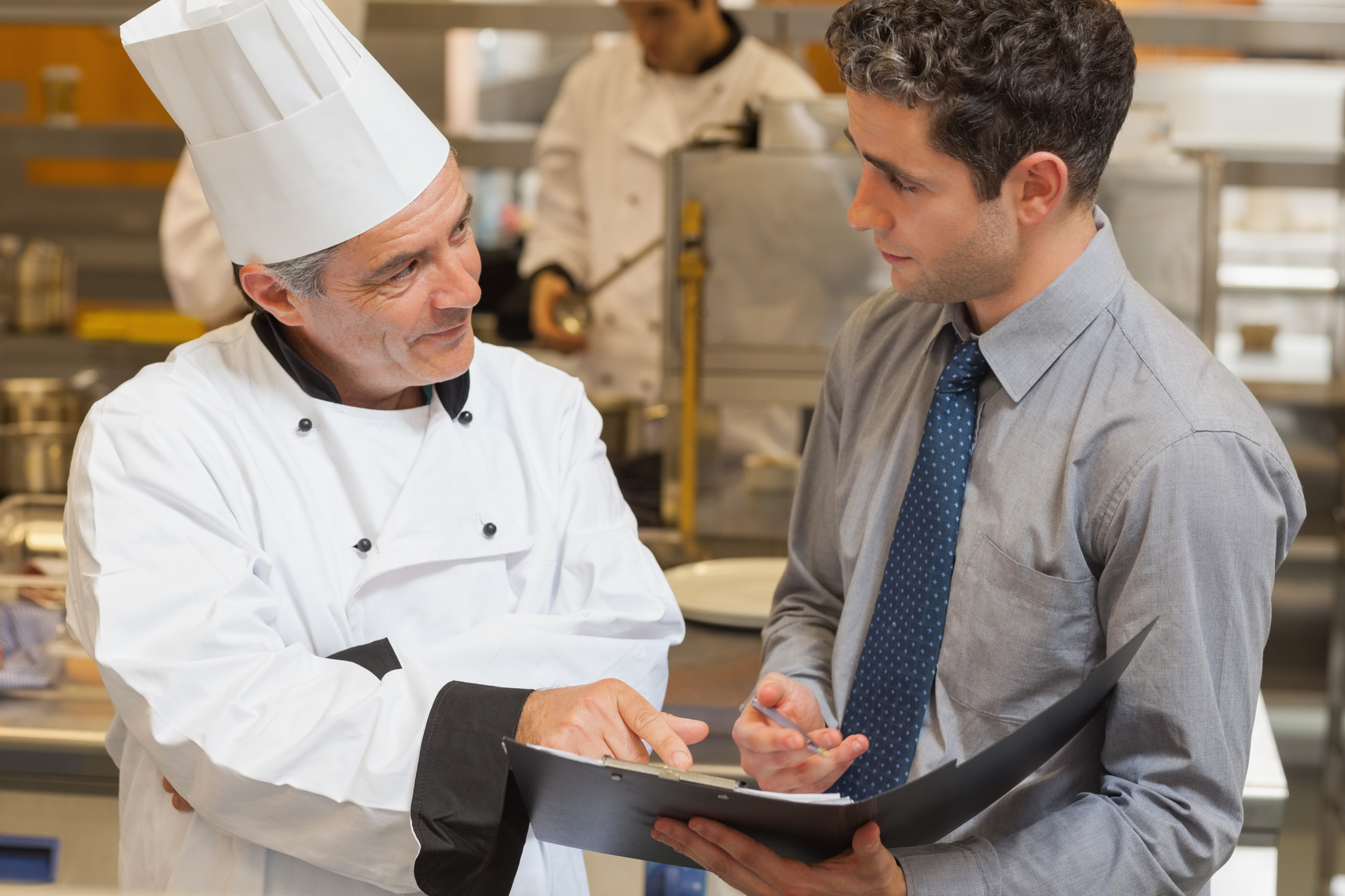 Waiter And Chef Discussing The Menu